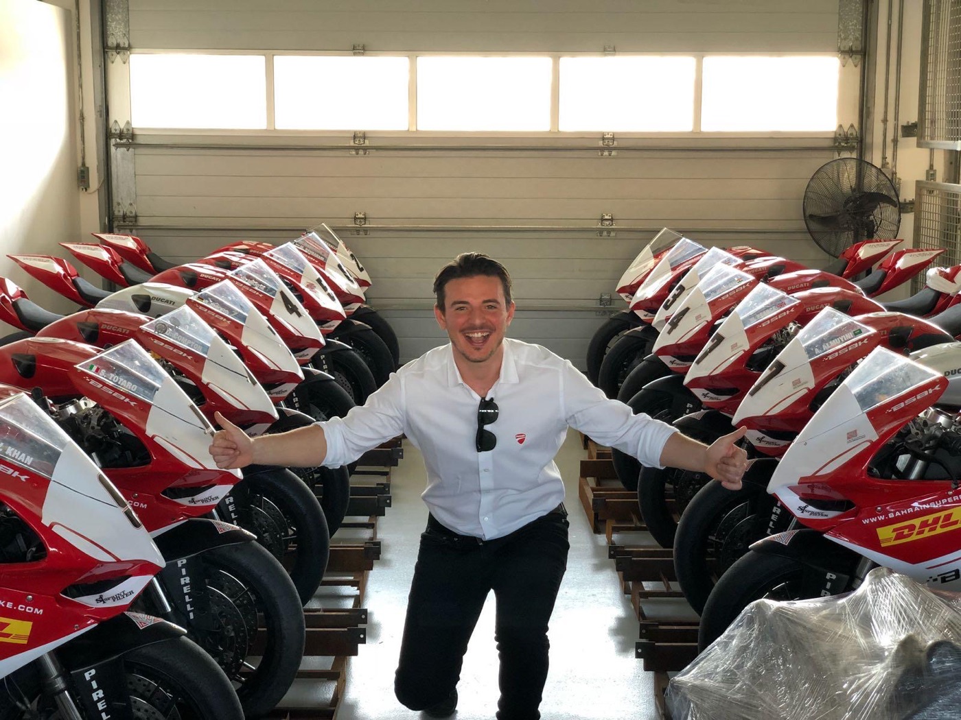 Filippo grinning between two rows of race-liveried superbikes in a garage in Bahrain